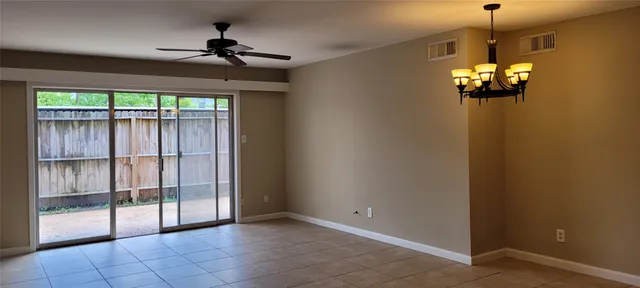 a view of a livingroom with a chandelier fan and windows