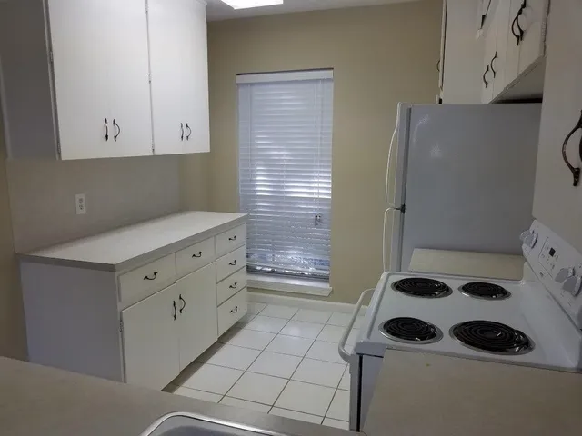 a kitchen with a refrigerator and a stove