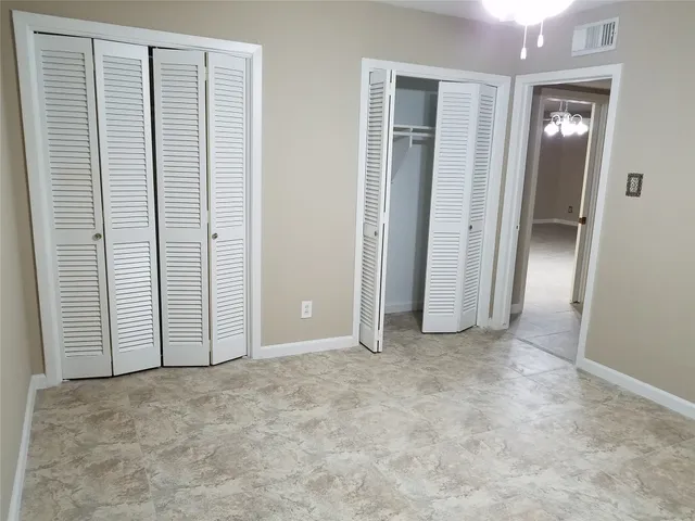 an empty room with closet and a bathroom