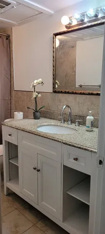 a bathroom with a granite countertop sink and a mirror