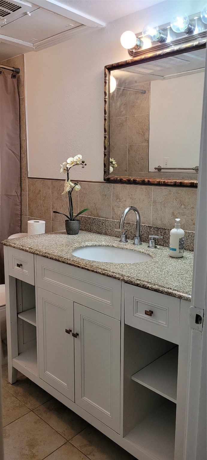 9031 Rue Cambon Street, Unit 69 Houston, TX 77074 - Photo 10 of 13 a bathroom with a granite countertop sink and a mirror