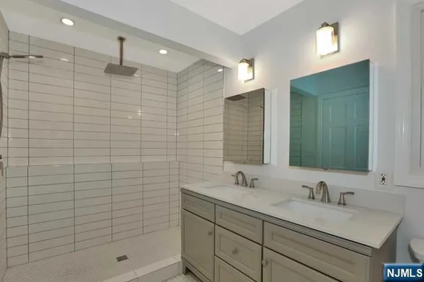 a bathroom with a shower sink and mirror