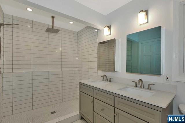 89 Wyoming Road Paramus, NJ 07652 - Photo 16 of 17 a bathroom with a shower sink and mirror
