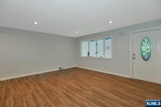 89 Wyoming Road Paramus, NJ 07652 - Photo 4 of 17 an empty room with wooden floor and mirror