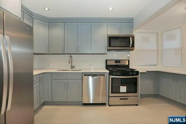 a kitchen with stainless steel appliances granite countertop a sink and a stove top oven