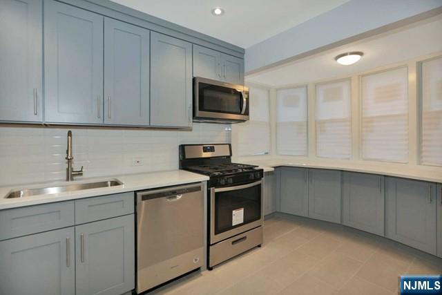 89 Wyoming Road Paramus, NJ 07652 - Photo 9 of 17 a kitchen with stainless steel appliances granite countertop a sink stove and microwave