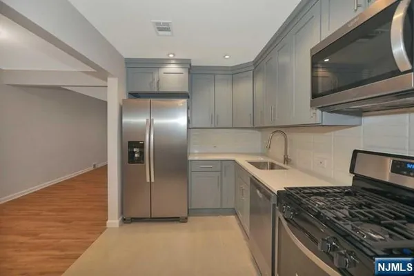 a kitchen with stainless steel appliances granite countertop a sink and a stove