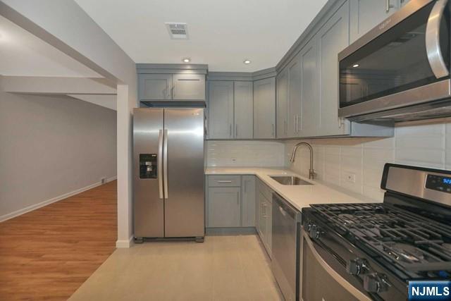 89 Wyoming Road Paramus, NJ 07652 - Photo 10 of 17 a kitchen with stainless steel appliances granite countertop a sink and a stove