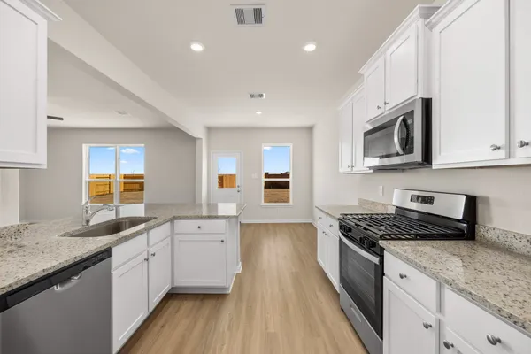 a kitchen with stainless steel appliances granite countertop a sink stove and cabinets