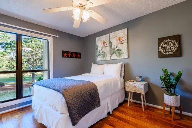 a bedroom with a large bed and a potted plant