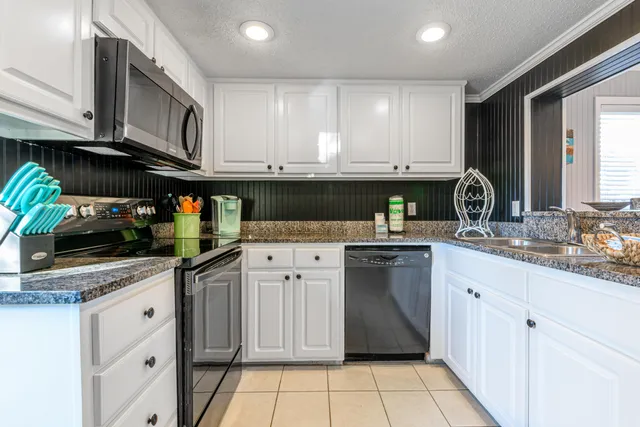 a kitchen with stainless steel appliances granite countertop a sink stove and cabinets