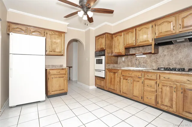 a kitchen with stainless steel appliances granite countertop a refrigerator a stove and a sink with granite countertops