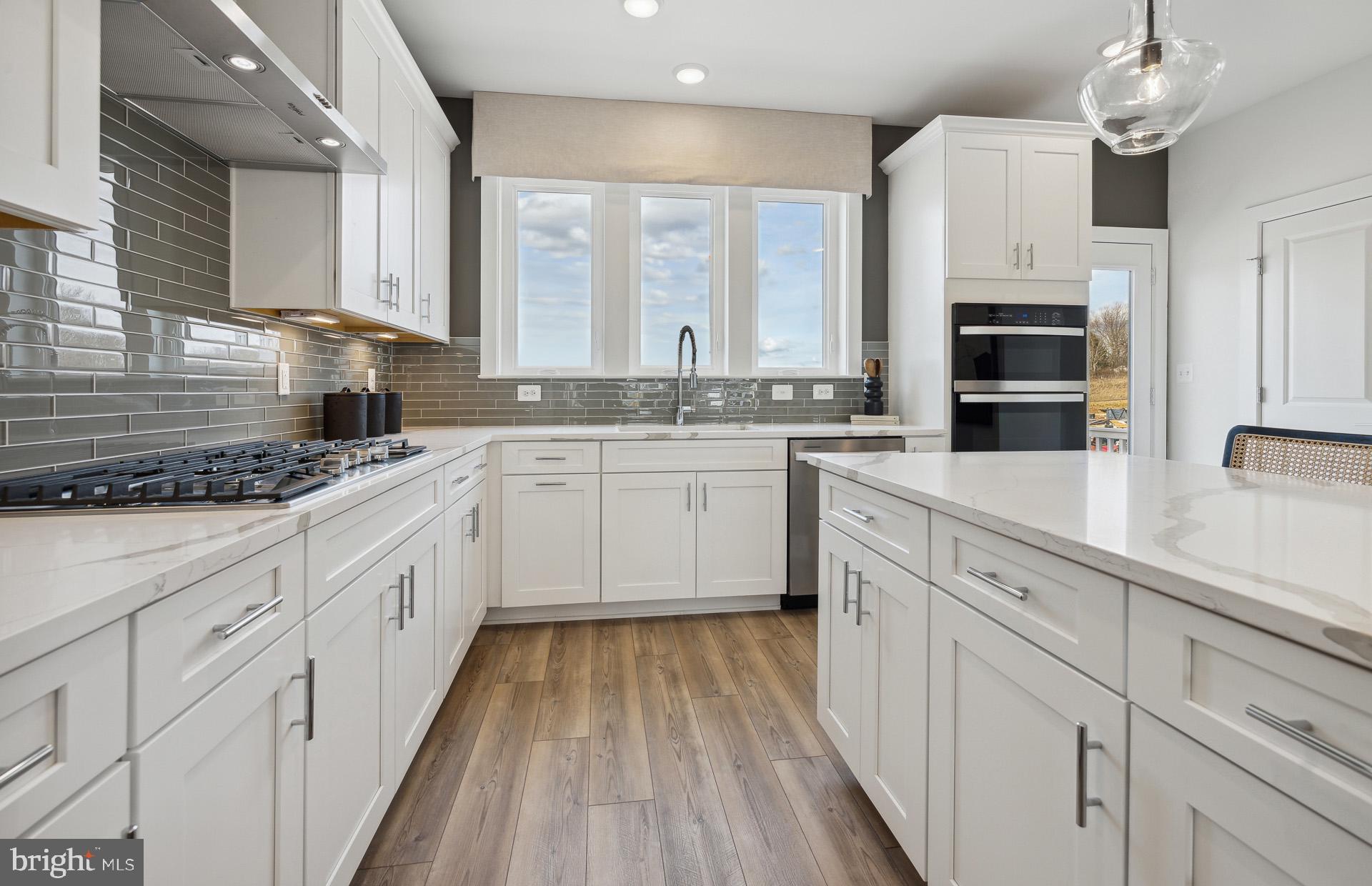 22412 Sculpin Brk Road Boyds, MD 20841 - Photo 3 of 37 a kitchen with stainless steel appliances kitchen island granite countertop a stove sink and cabinets