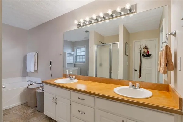 a bathroom with a granite countertop double vanity sink and a mirror