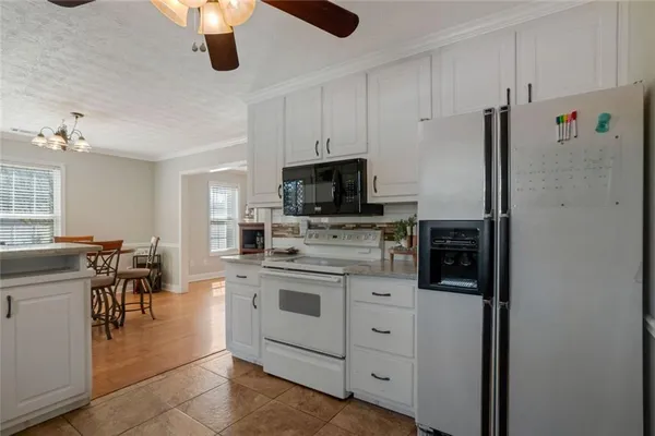 a kitchen with kitchen island granite countertop appliances cabinets and a counter space