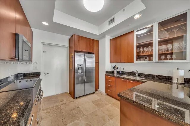 a kitchen with stainless steel appliances granite countertop a stove a sink and a refrigerator