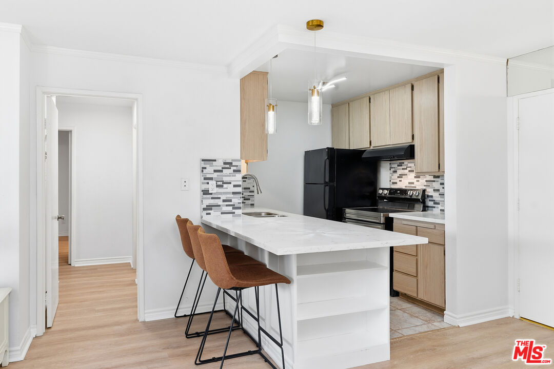 a kitchen with kitchen island white cabinets and stainless steel appliances