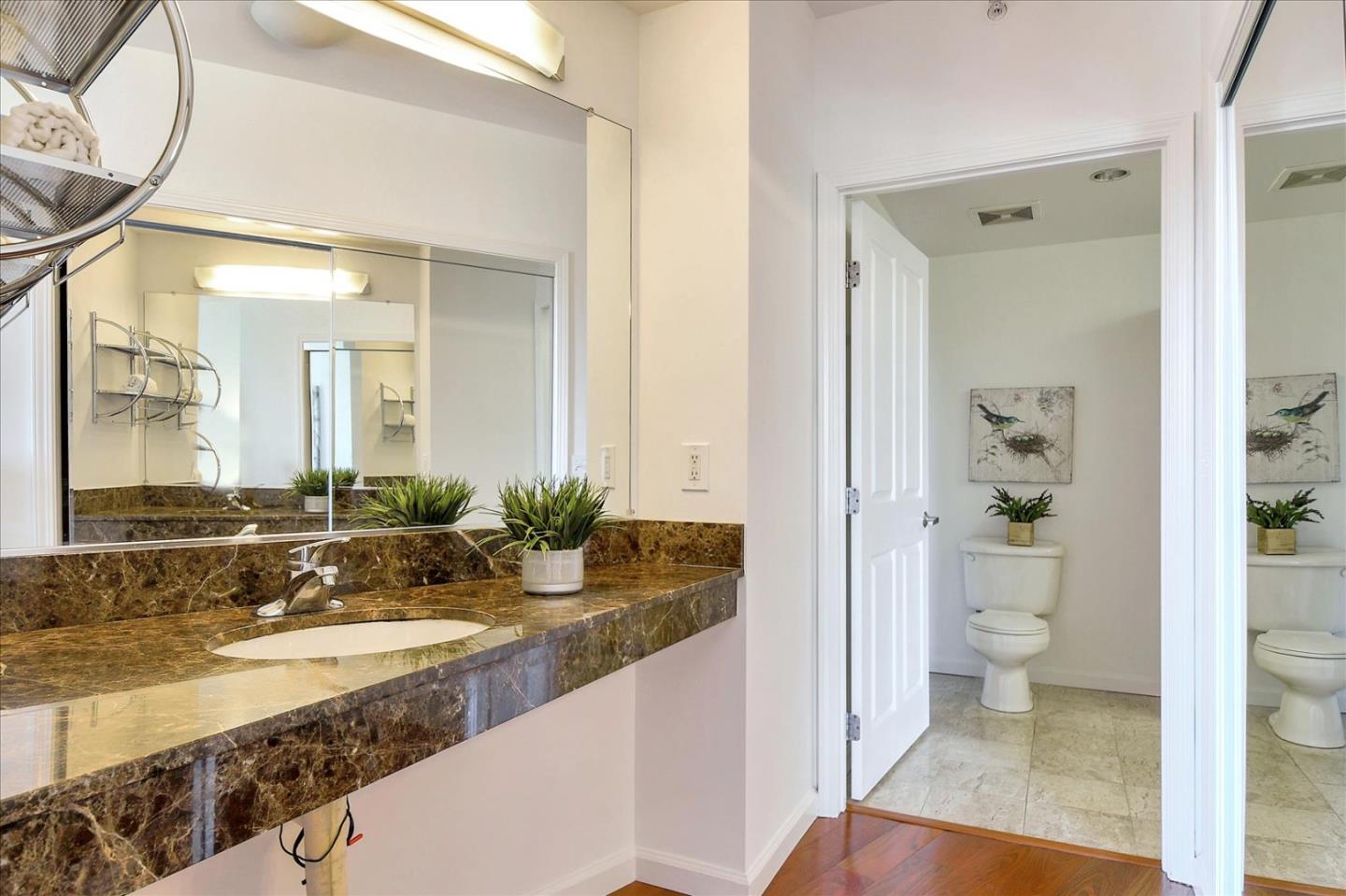 140 South Van Ness Avenue, Unit 422 San Francisco, CA 94103 - Photo 20 of 32 a bathroom with a granite countertop sink a toilet and shower