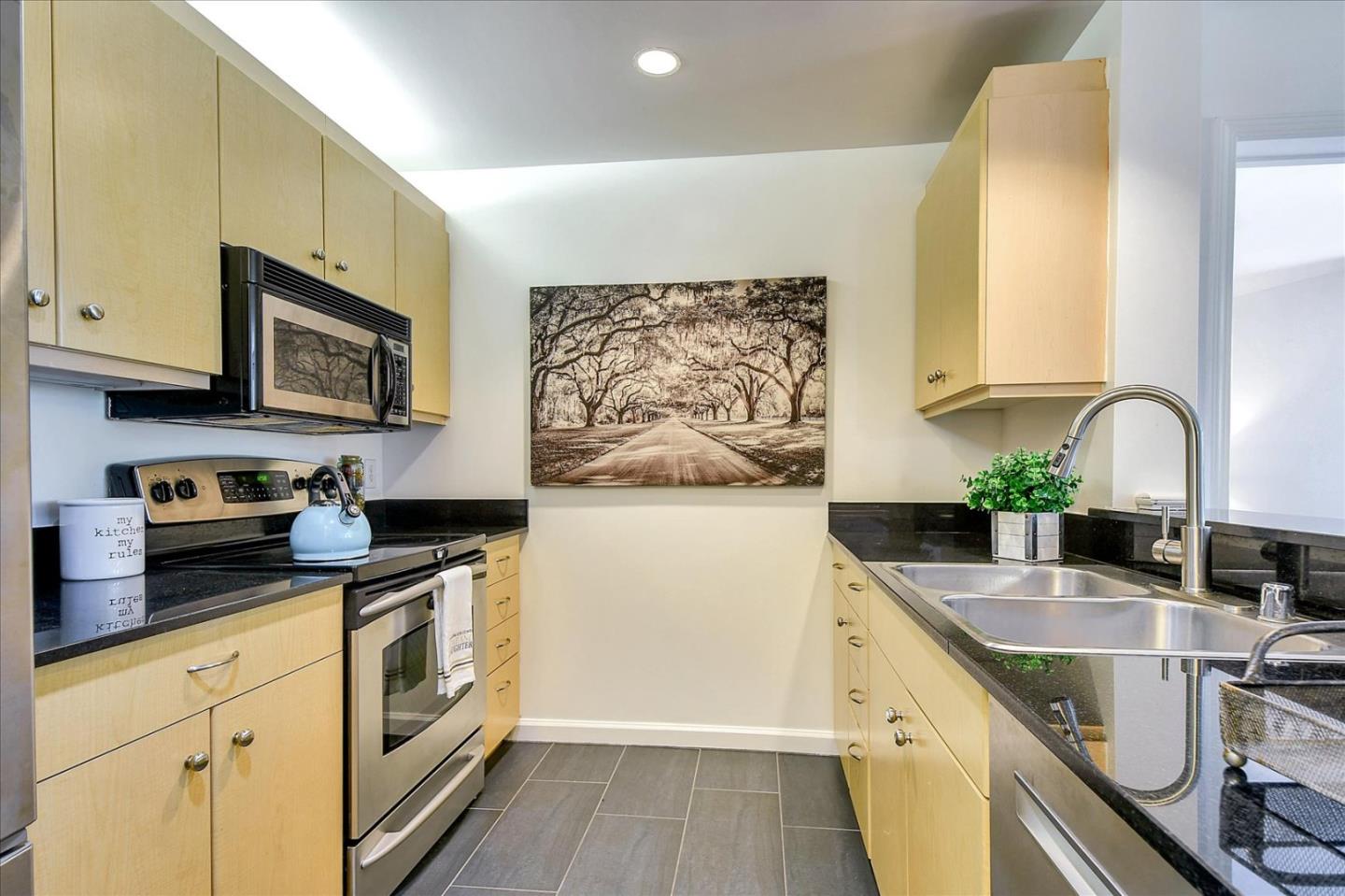140 South Van Ness Avenue, Unit 422 San Francisco, CA 94103 - Photo 5 of 32 a kitchen with granite countertop a stove a sink and cabinets