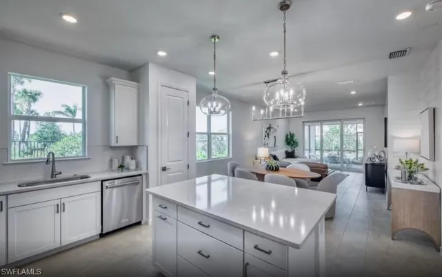 a large kitchen with granite countertop a sink dishwasher a dining table chairs and couches