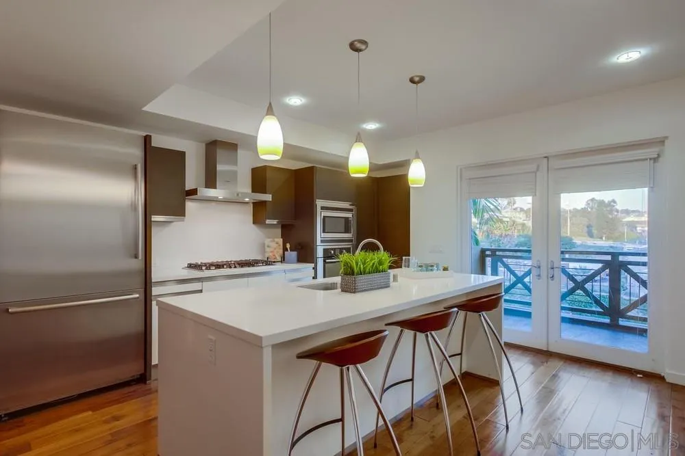 90 North Coast Highway 101, Unit 312 Encinitas, CA 92024 - Photo 14 of 19 a kitchen with kitchen island a large counter top space and stainless steel appliances