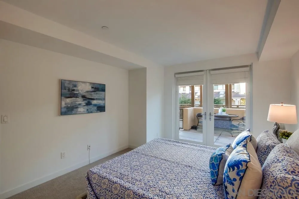 90 North Coast Highway 101, Unit 312 Encinitas, CA 92024 - Photo 3 of 19 a bedroom with a large bed a rug and chair