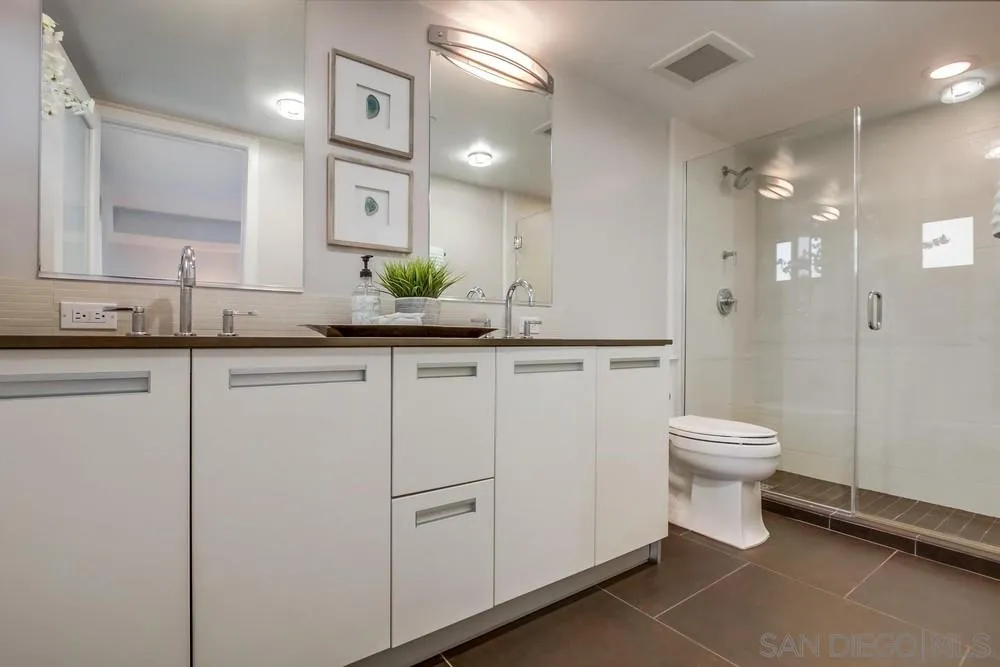 90 North Coast Highway 101, Unit 312 Encinitas, CA 92024 - Photo 5 of 19 a bathroom with a granite countertop sink a toilet and a mirror