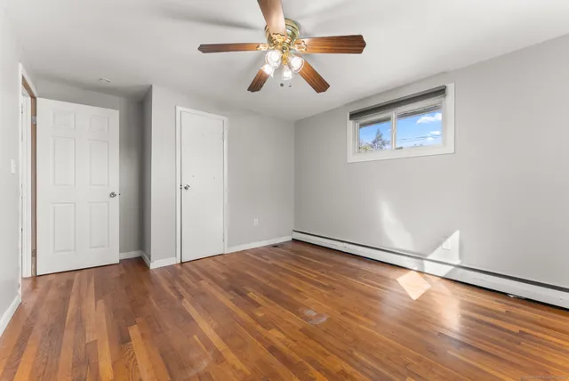 a view of empty room with wooden floor