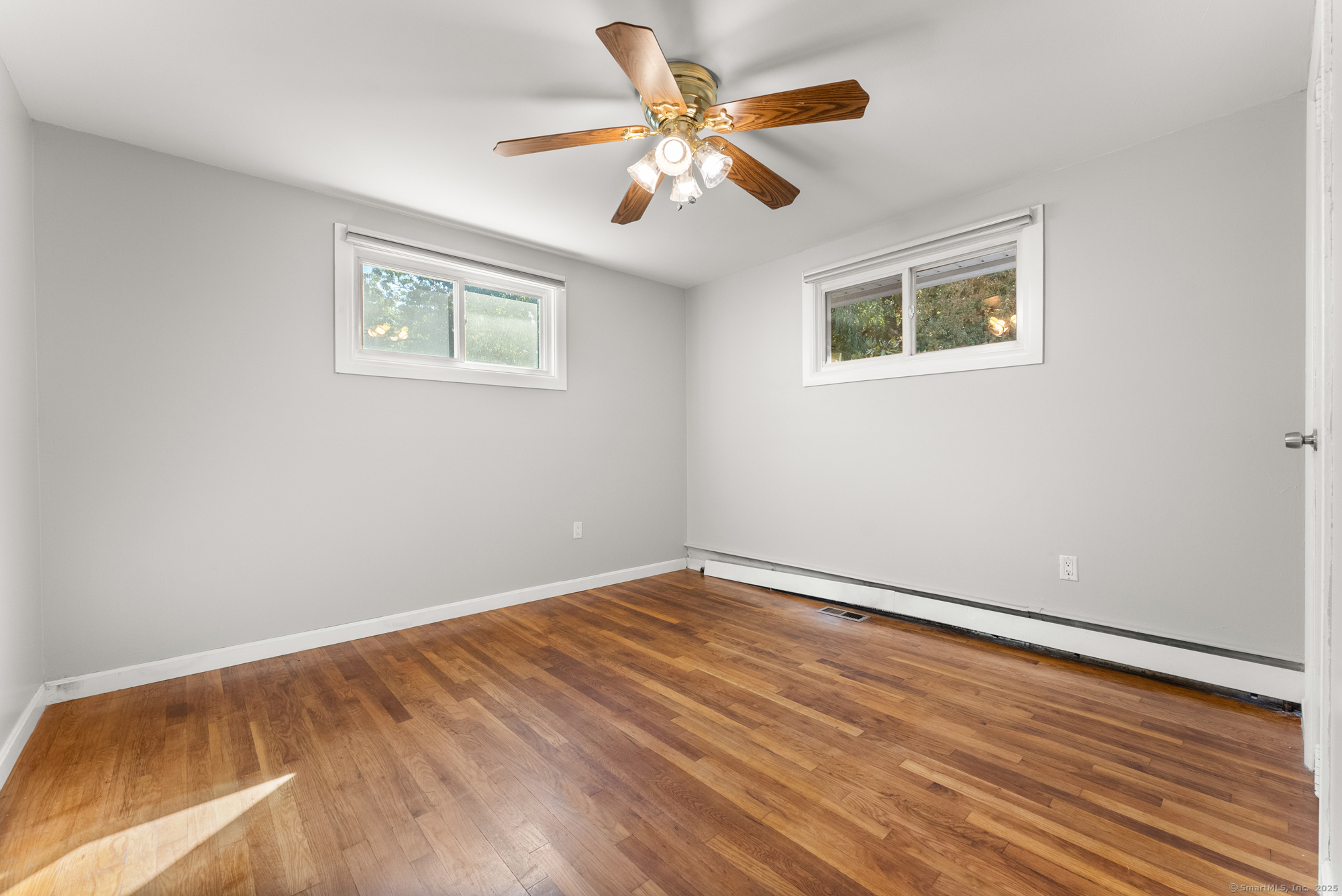 91 Till Street Enfield, CT 06082 - Photo 12 of 30 a view of an empty room with wooden floor and a ceiling fan