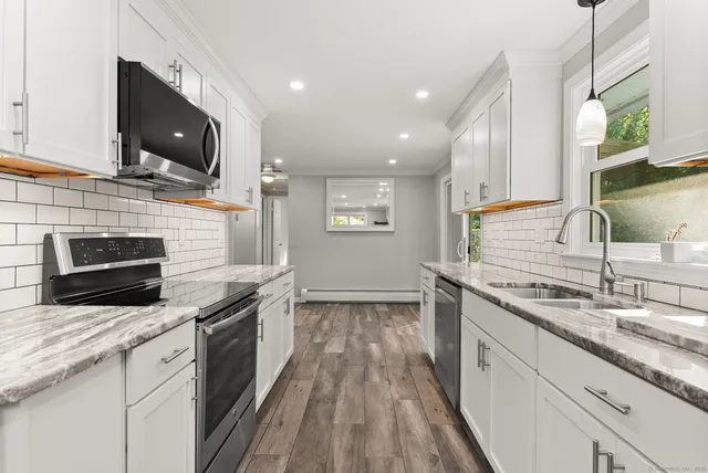 a kitchen with stainless steel appliances wooden cabinets granite counter tops and a stove