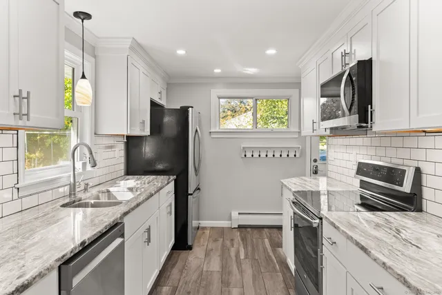a kitchen with stainless steel appliances granite countertop a sink stove and refrigerator