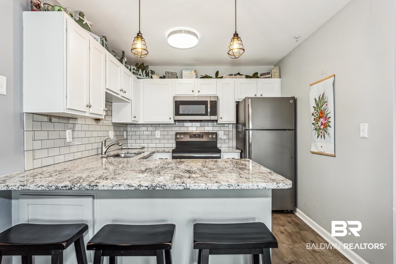 13551 Johnson Beach Road, Unit 112E Pensacola, FL 32507 - Photo 13 of 42 Kitchen with sink, kitchen peninsula, white cabinets, and stainless steel appliances