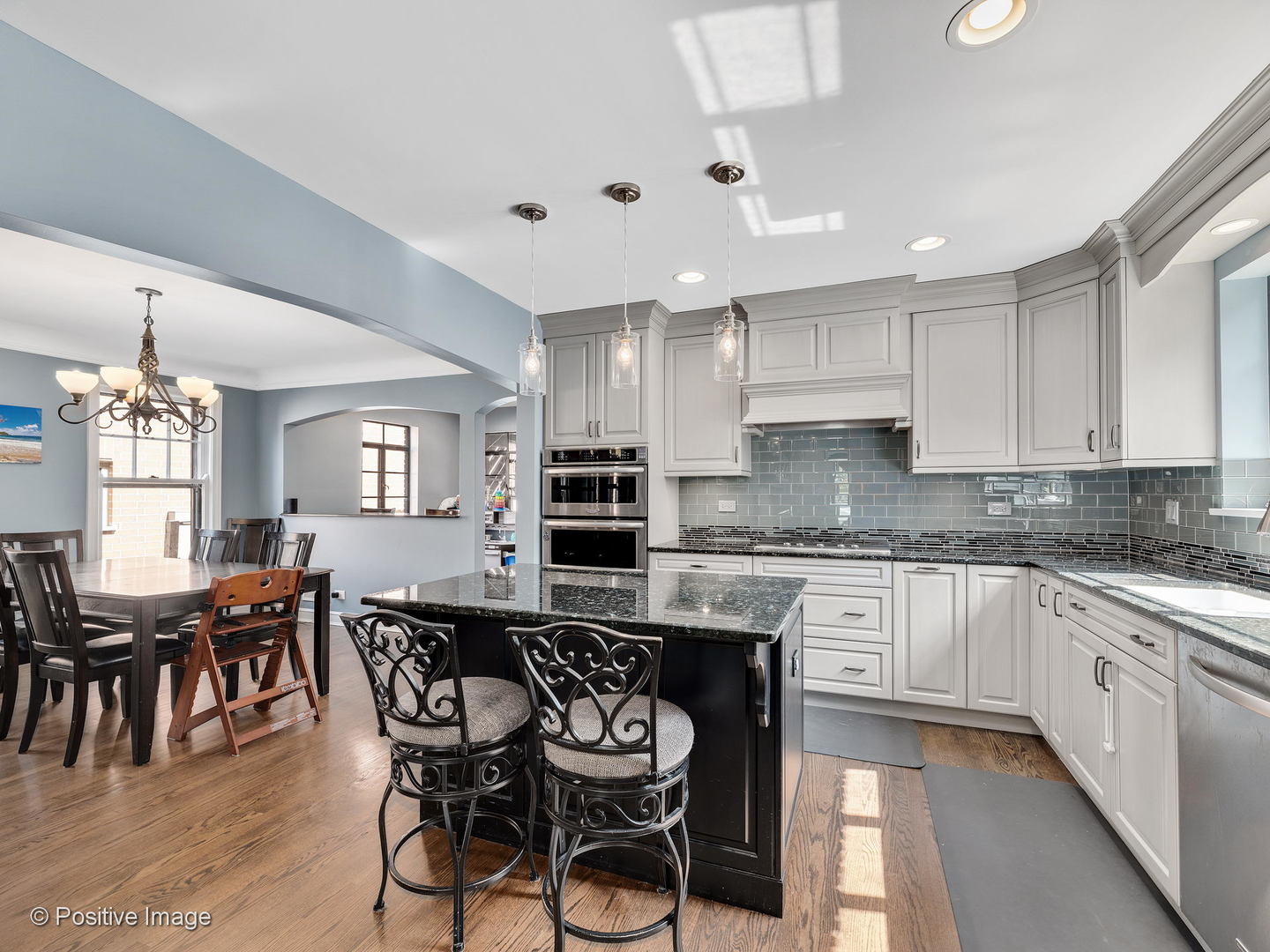 331 Selborne Road Riverside, IL 60546 - Photo 4 of 19 a kitchen with stainless steel appliances kitchen island granite countertop a dining table chairs and white cabinets