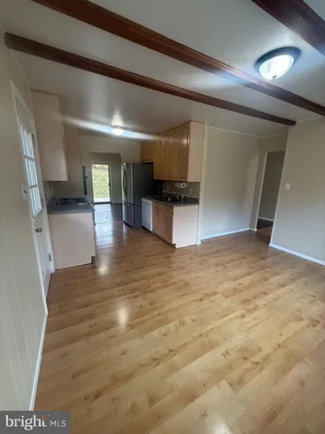a view of empty room with kitchen and sink