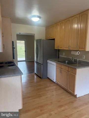 a kitchen with granite countertop a refrigerator and a sink