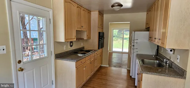 a kitchen with granite countertop a sink stove and cabinets