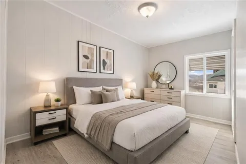 a bedroom with a bed a mirror and a large window