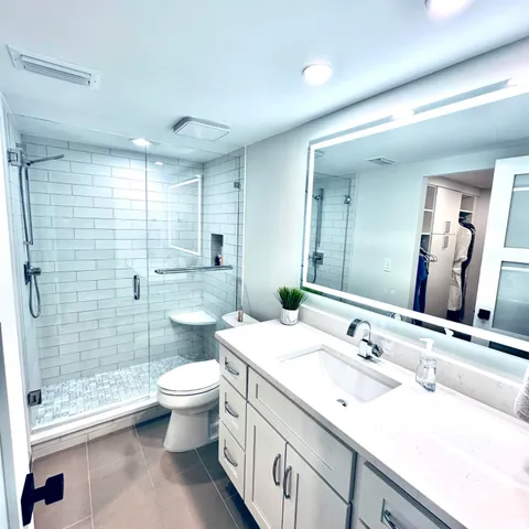 a bathroom with a double vanity sink toilet and shower