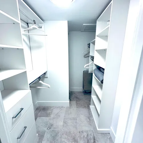 a view of walk in closet with empty racks