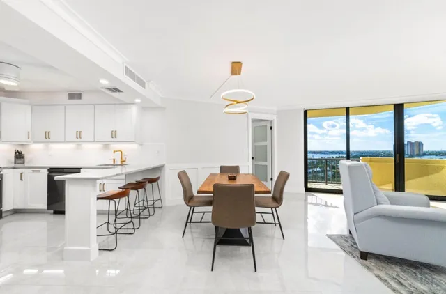 a dining room with stainless steel appliances kitchen island granite countertop a table and chairs in it
