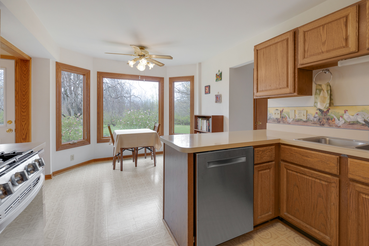 43W330 Main Street Road Elburn, IL 60119 - Photo 13 of 34 a kitchen with granite countertop a stove a sink a dining table and chairs