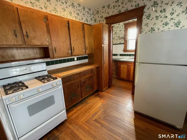 a white refrigerator freezer and a stove sitting inside of a kitchen