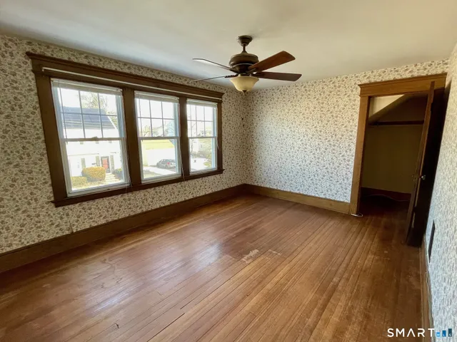 a view of empty room with wooden floor