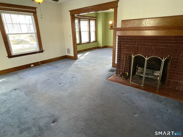a view of an empty room with window and fire place