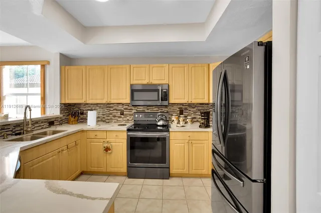 a kitchen with stainless steel appliances granite countertop a refrigerator stove and sink