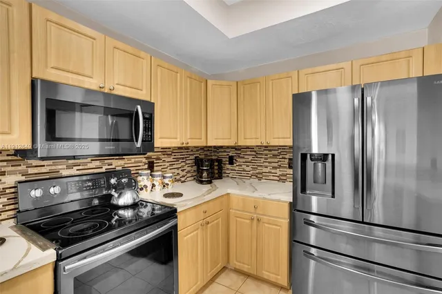a kitchen with stainless steel appliances granite countertop a refrigerator a stove top oven a sink and dishwasher