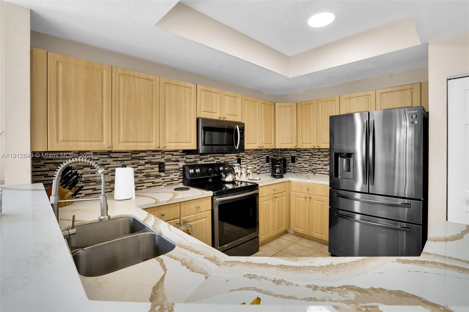 13117 Southwest 49th Court Miramar, FL 33027 - Photo 16 of 65 a kitchen with stainless steel appliances granite countertop a refrigerator a stove top oven a sink and dishwasher