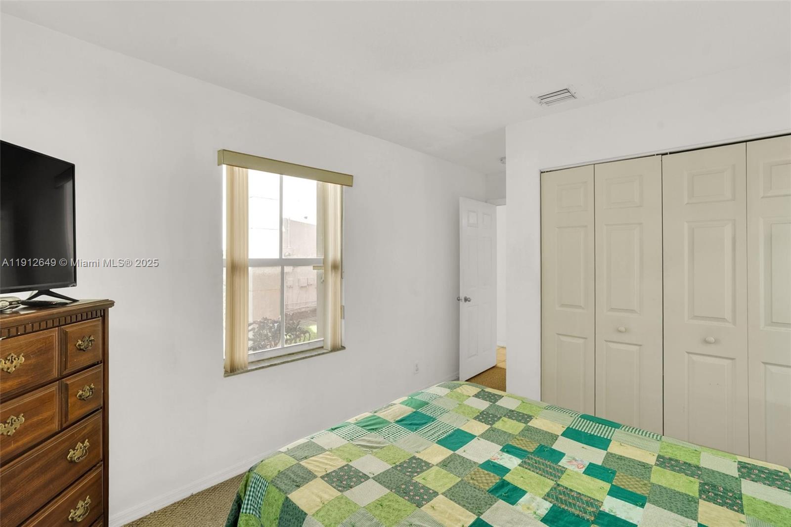 13117 Southwest 49th Court Miramar, FL 33027 - Photo 26 of 65 a bedroom with a bed and a flat tv screen on a dresser