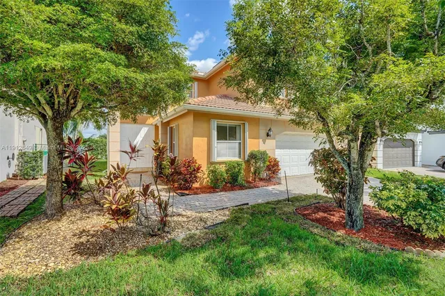 a view of a yard with a house and a large tree