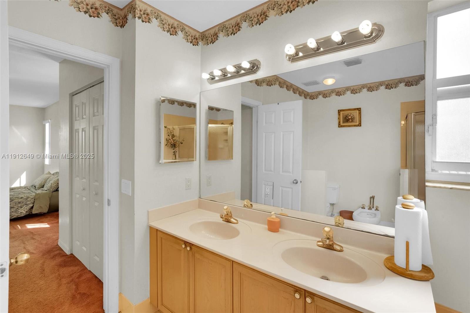 13117 Southwest 49th Court Miramar, FL 33027 - Photo 39 of 65 a bathroom with a sink double vanity and a mirror